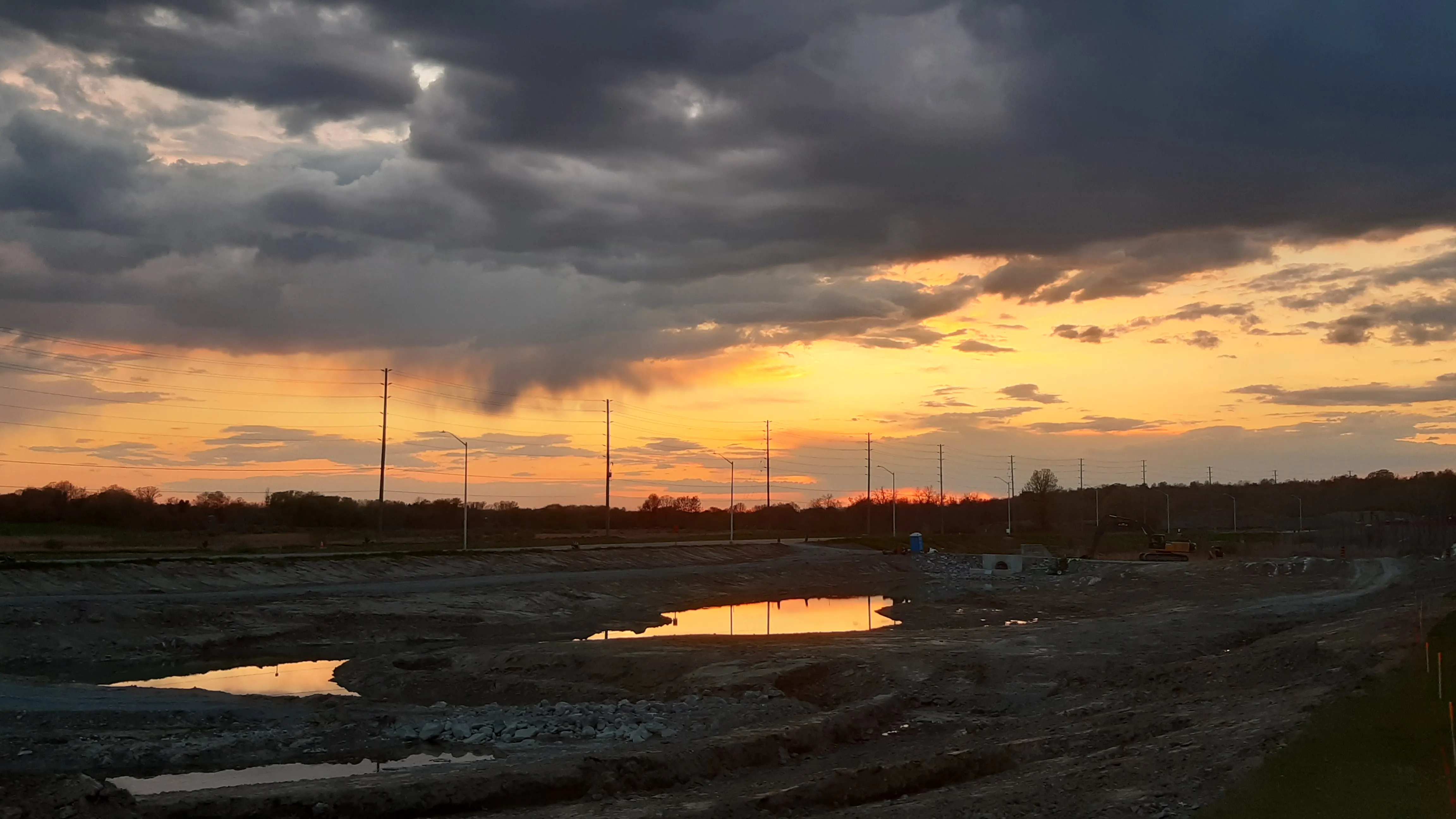 Orange and blue sunset with small ponds