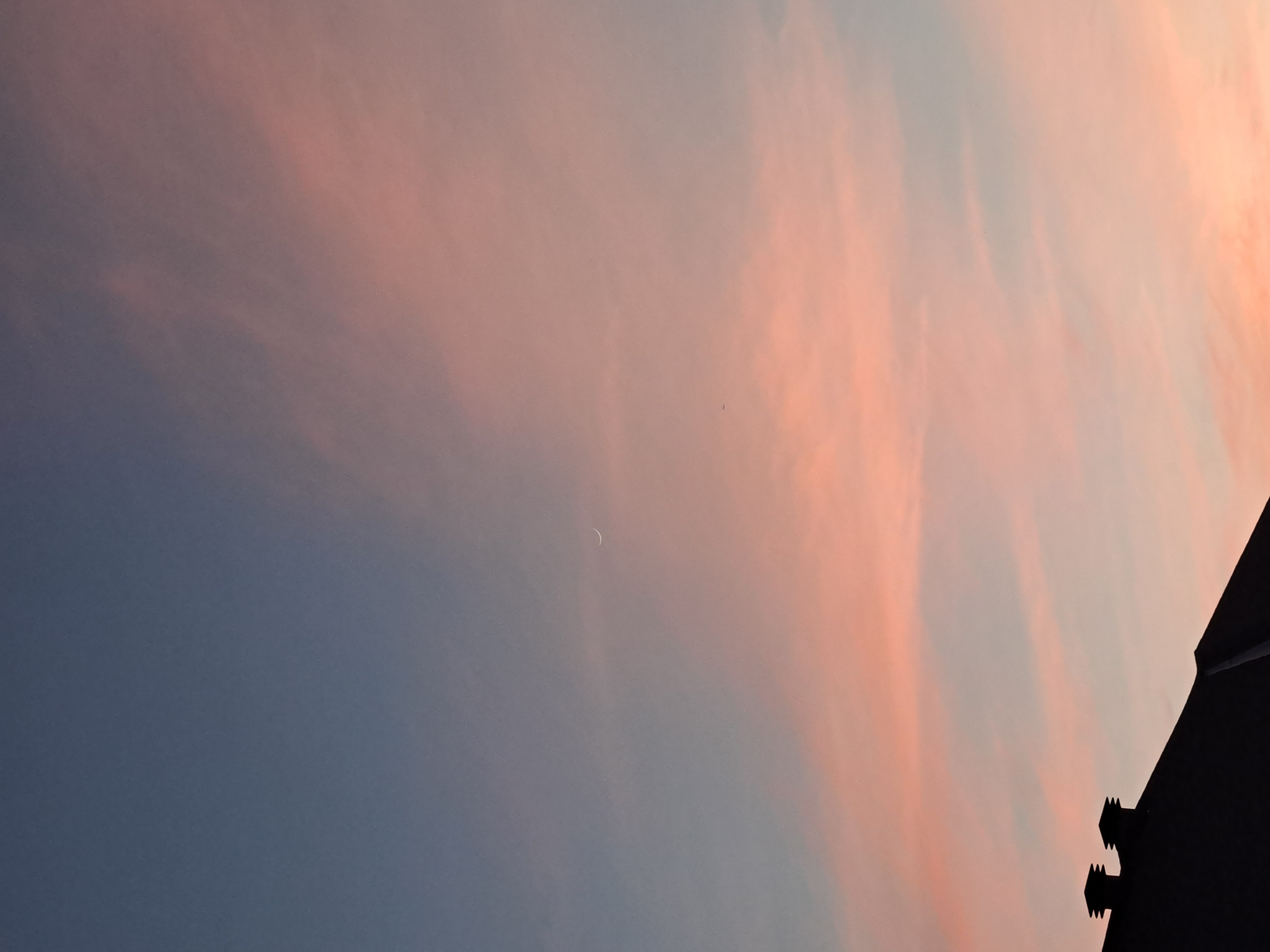 Pink and blue sunset above roof of house
