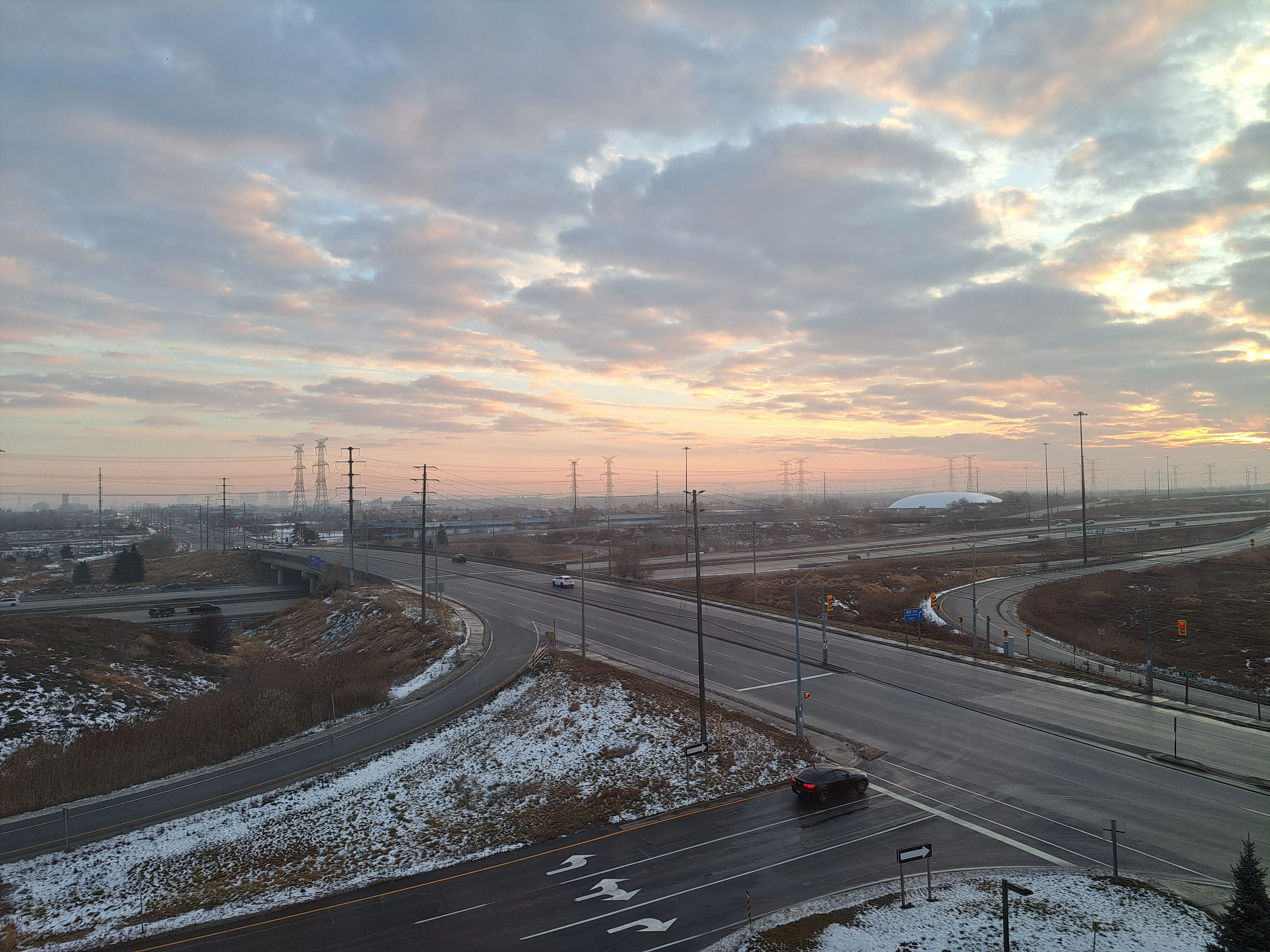 Pink cloudy sky above highway intersection in winter