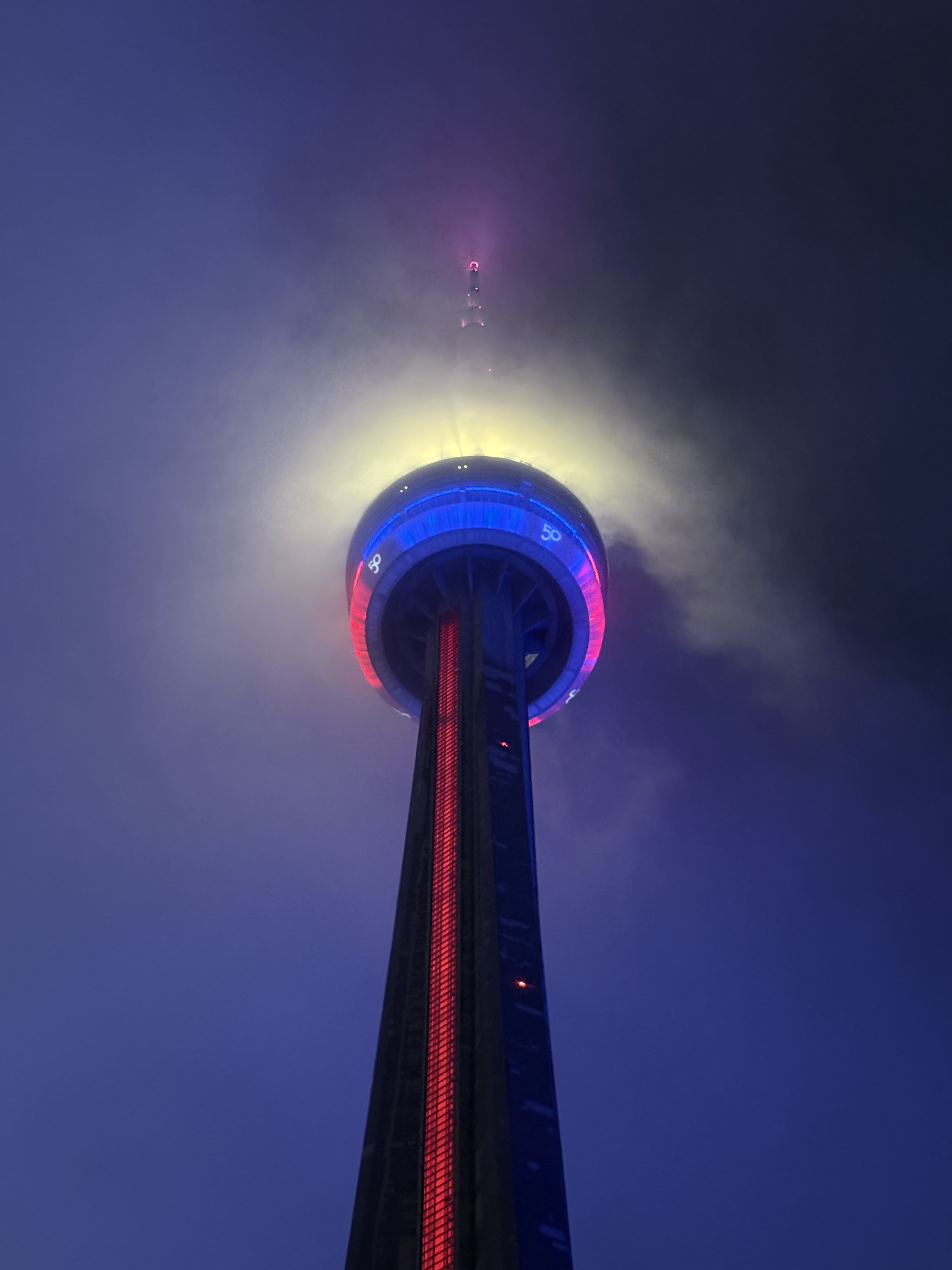 Closeup of CN Tower peak during a foggy evening