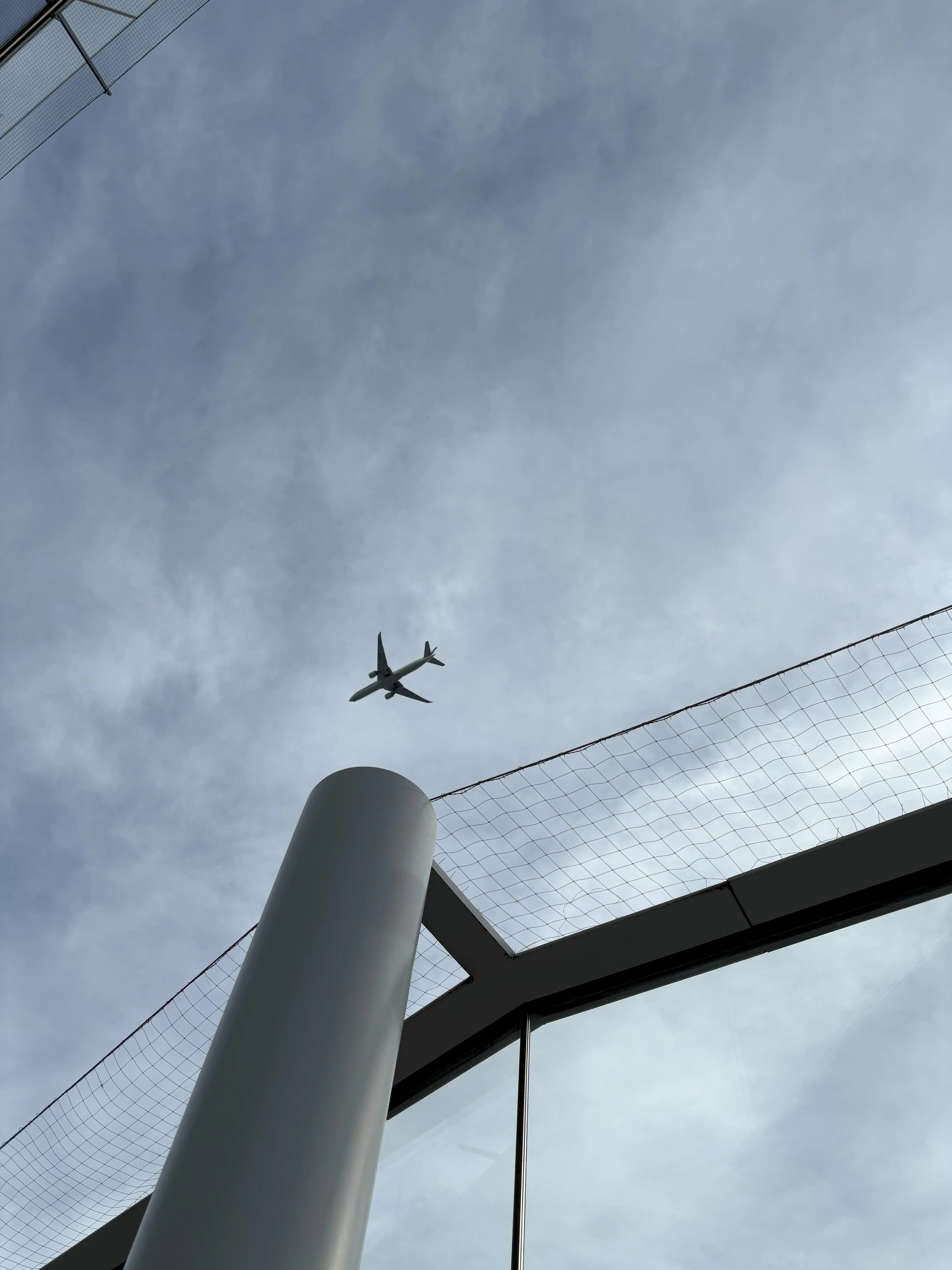 Plane passing in sky above a column