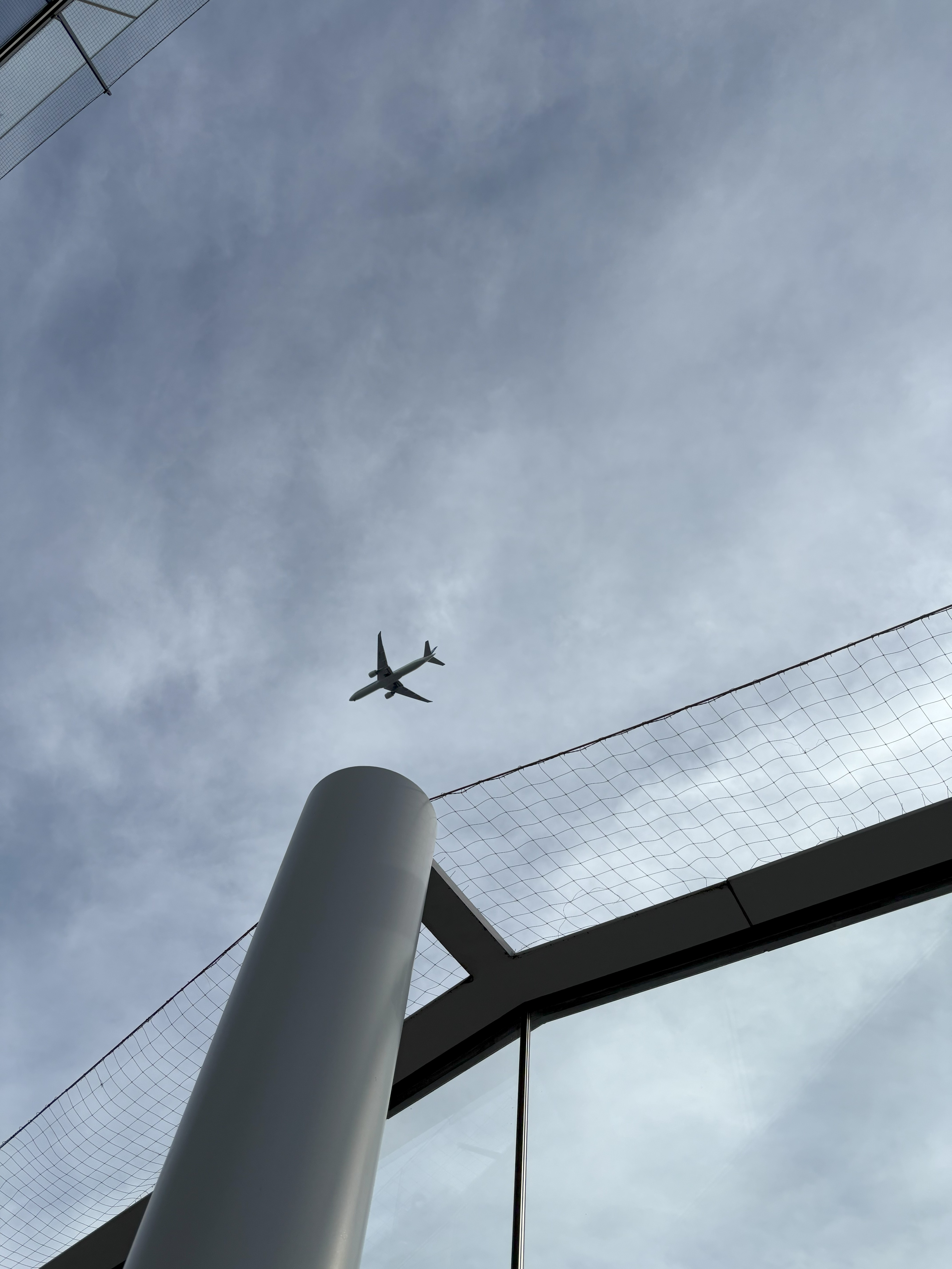 Plane passing in sky above a column