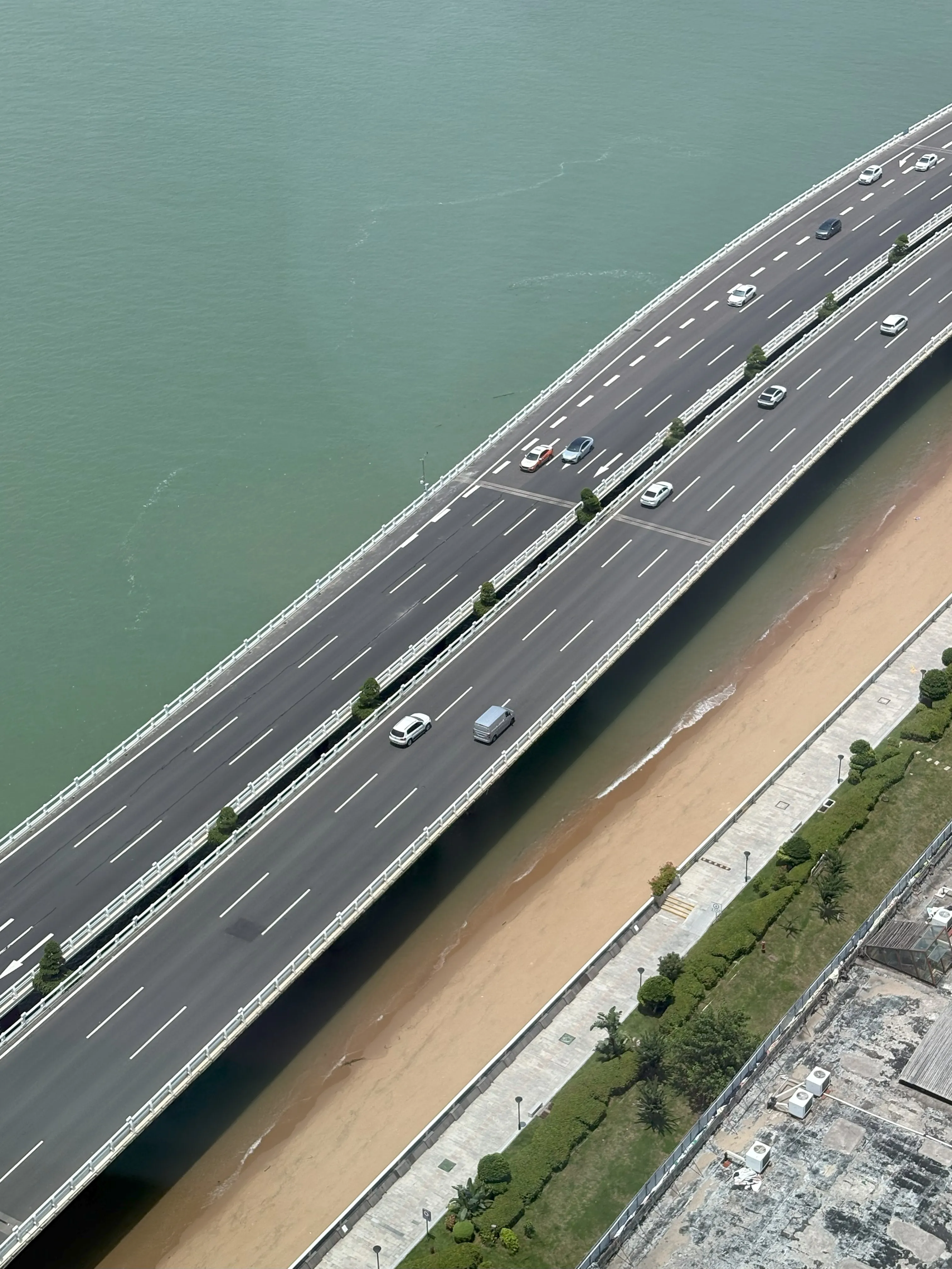 Bird's eye view of road raised above beach