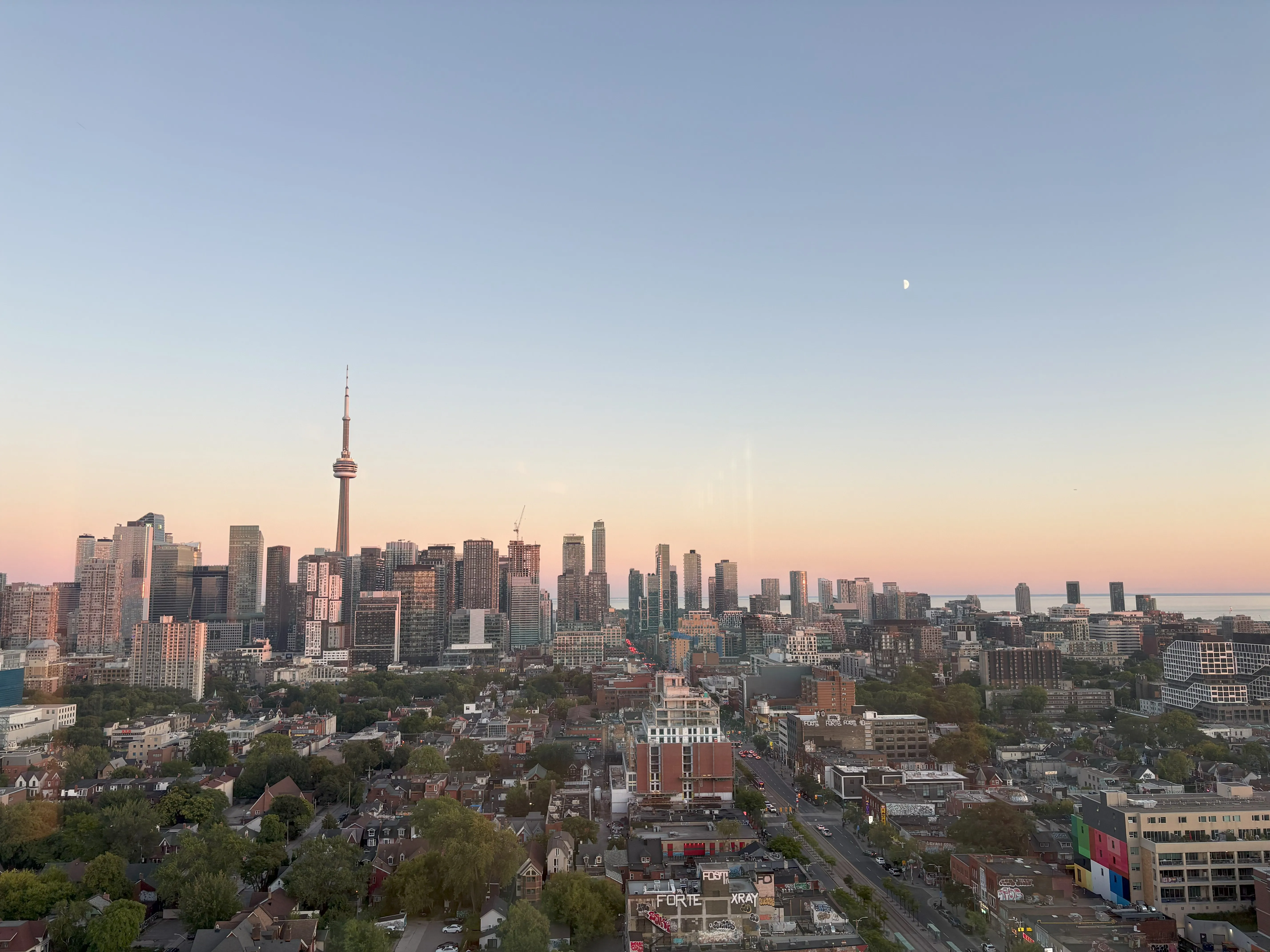 Blue and pink sunset above Toronto city skyline with moon