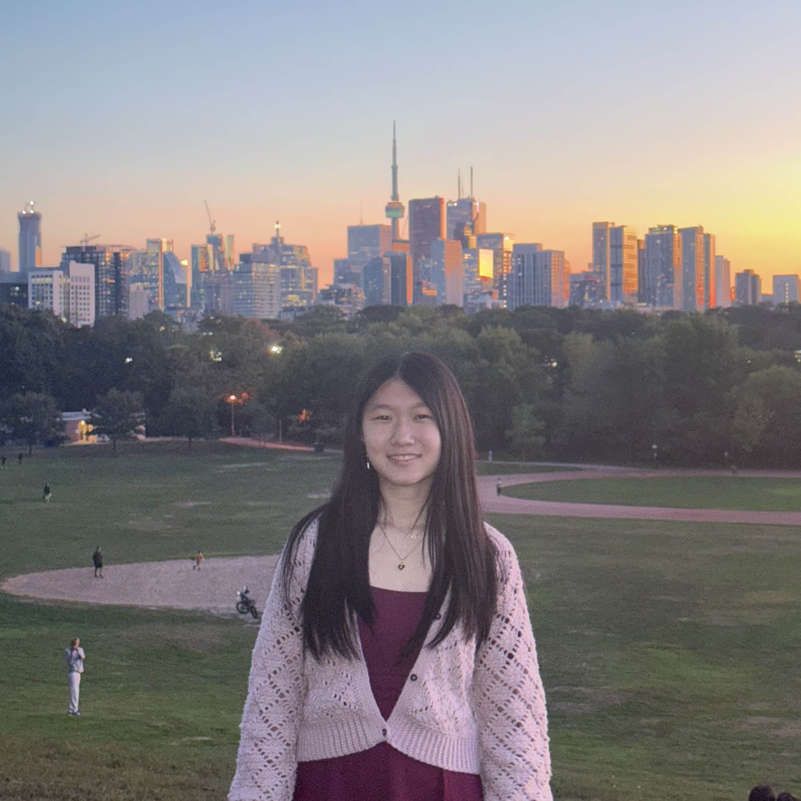 Angela in front of a pink and blue sunset