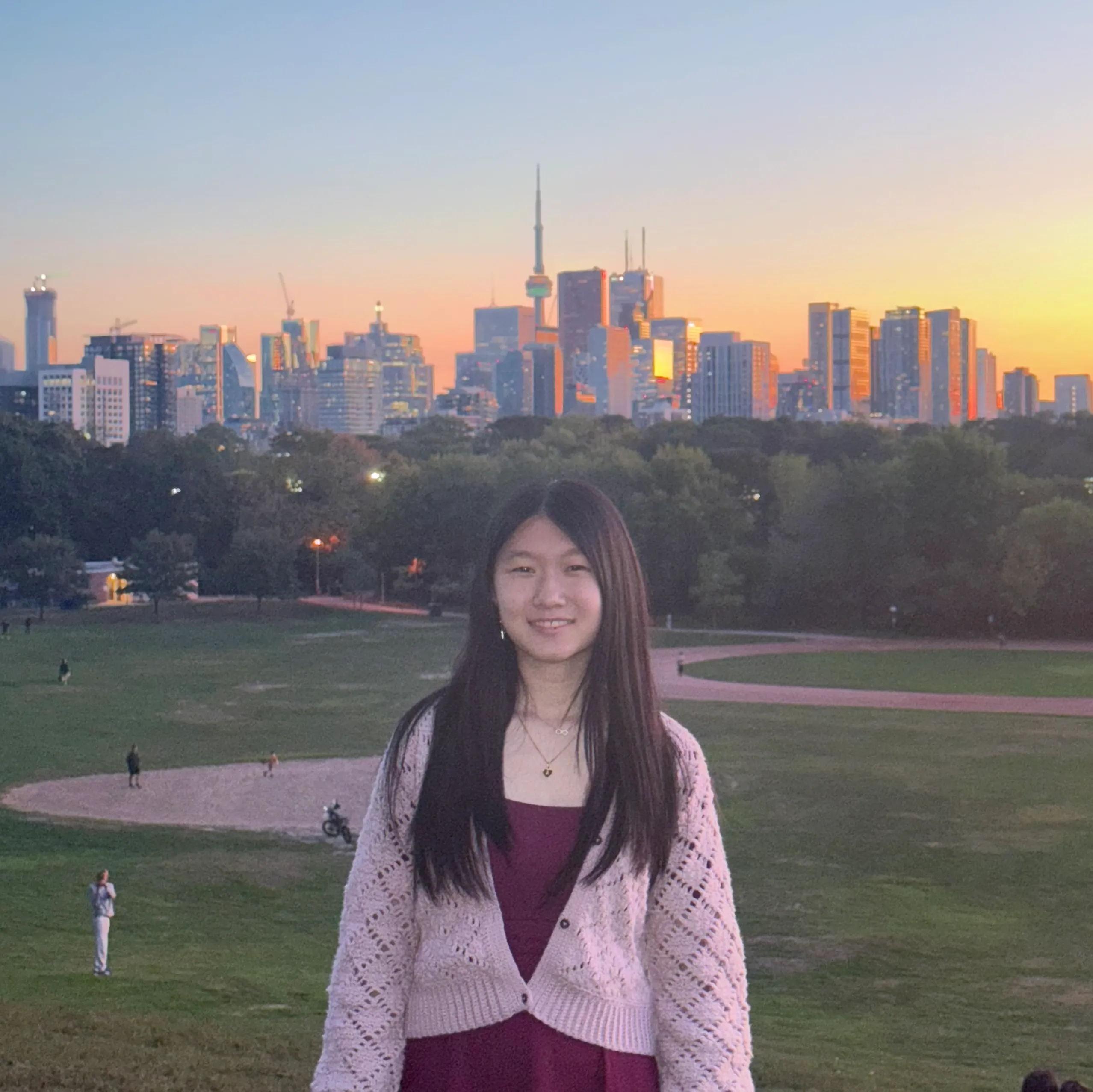 Angela in front of a pink and blue sunset